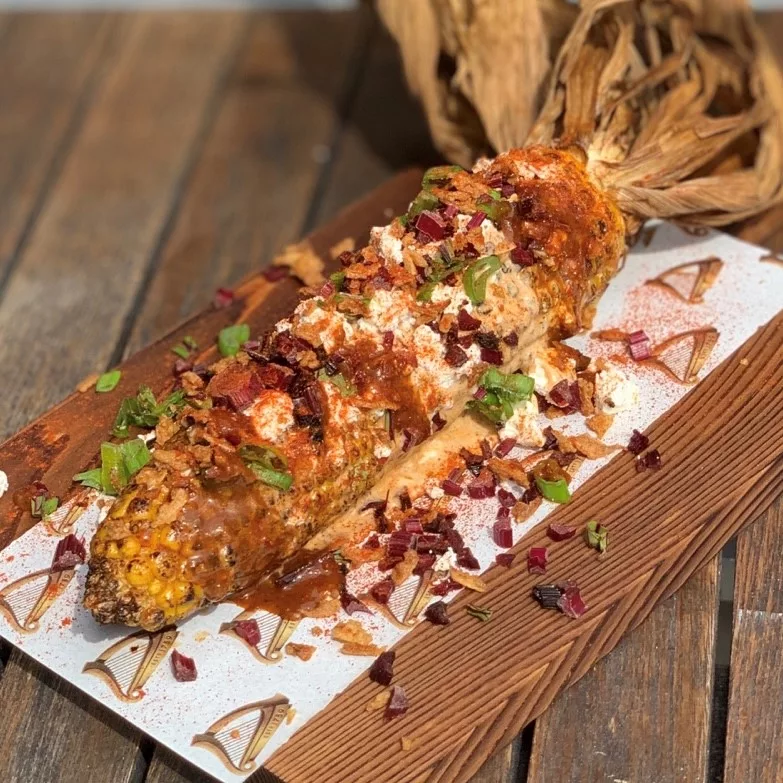 Corn on the cob seasoned with chilli, sour cream and diced vegetables
