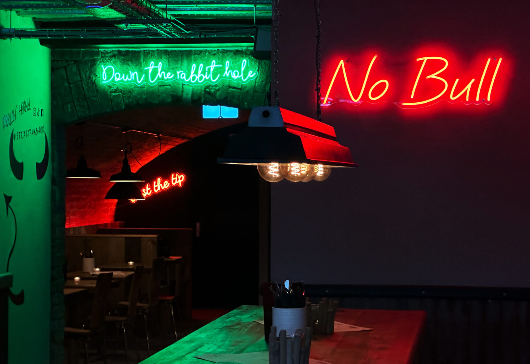 Strip Steak's signature neon signs. "Down the rabbit hole" and "No Bull".