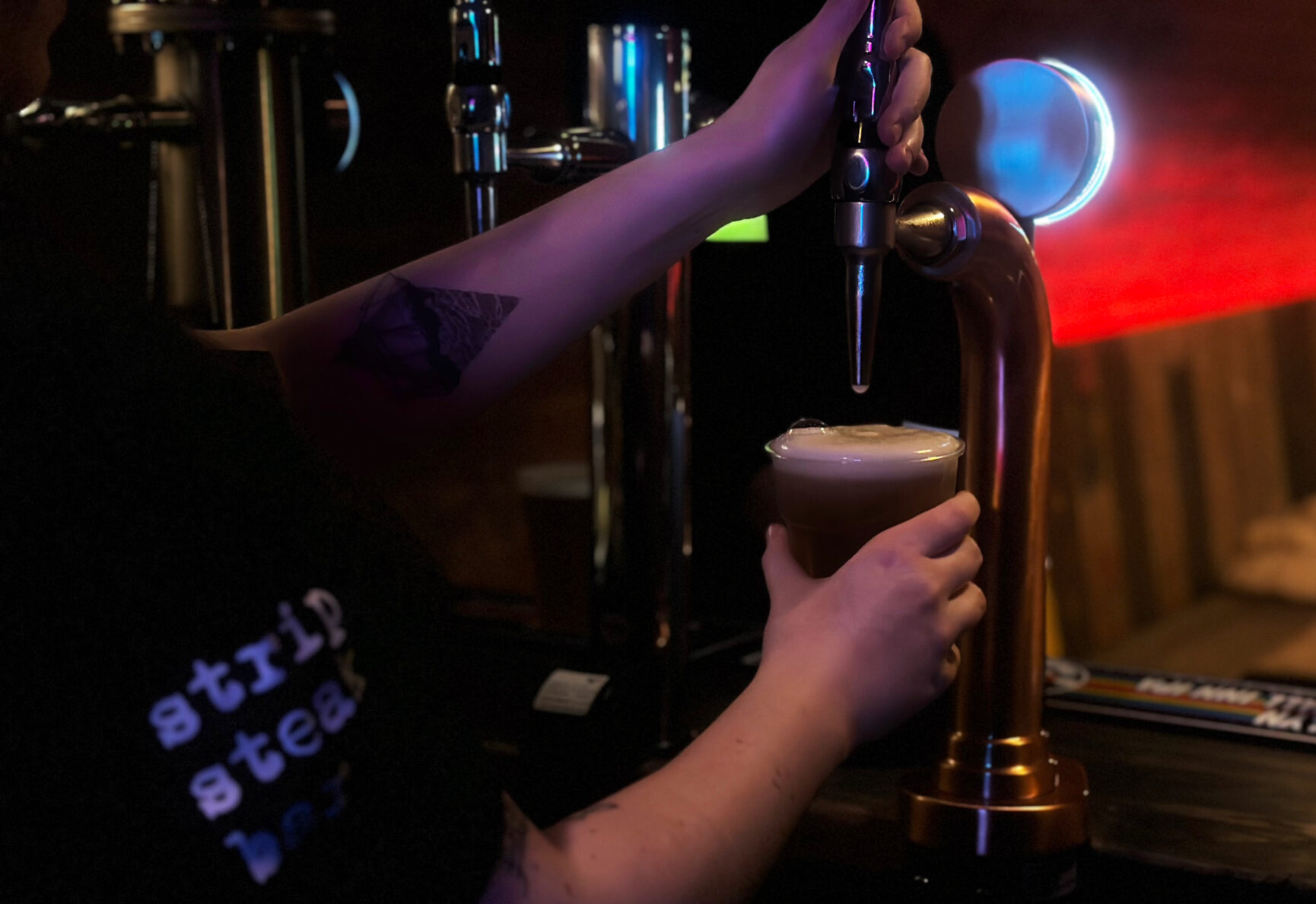 A bartender pours a pint at the Strip Steak Bar.