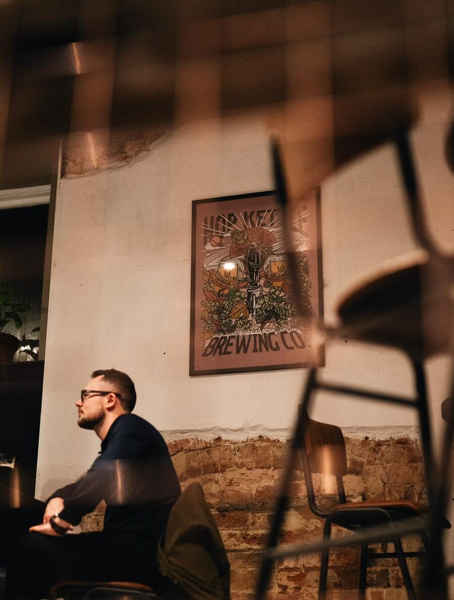 A man sits at a table in one of Hop Kettle's rooms at night.
