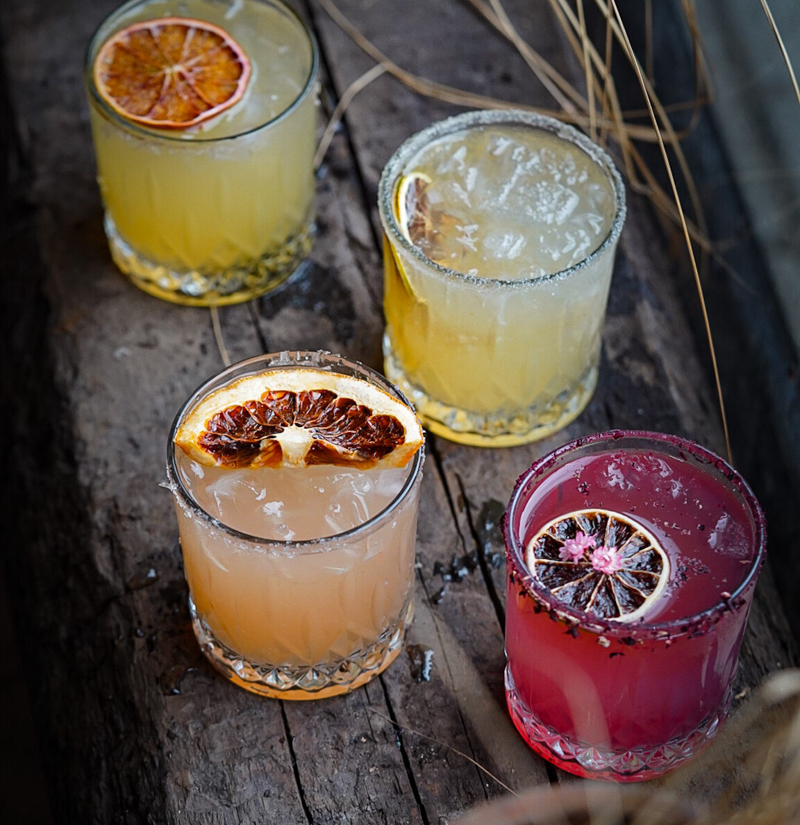 4 different Mexican Margaritas at Elote with citrus slice garnishes.