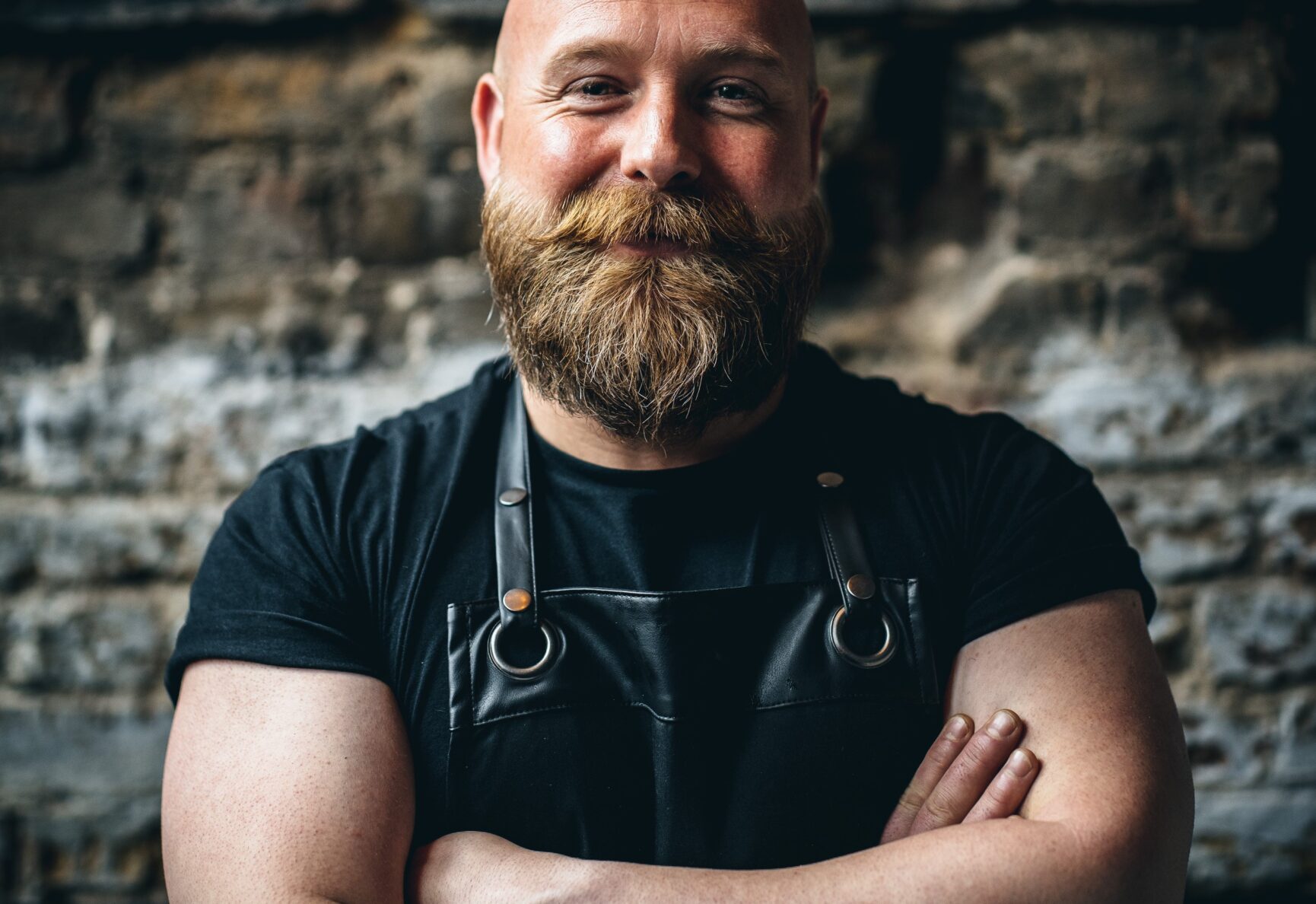 Lewis, owner of Chuck, stood smiling and wearing a black leather apron.