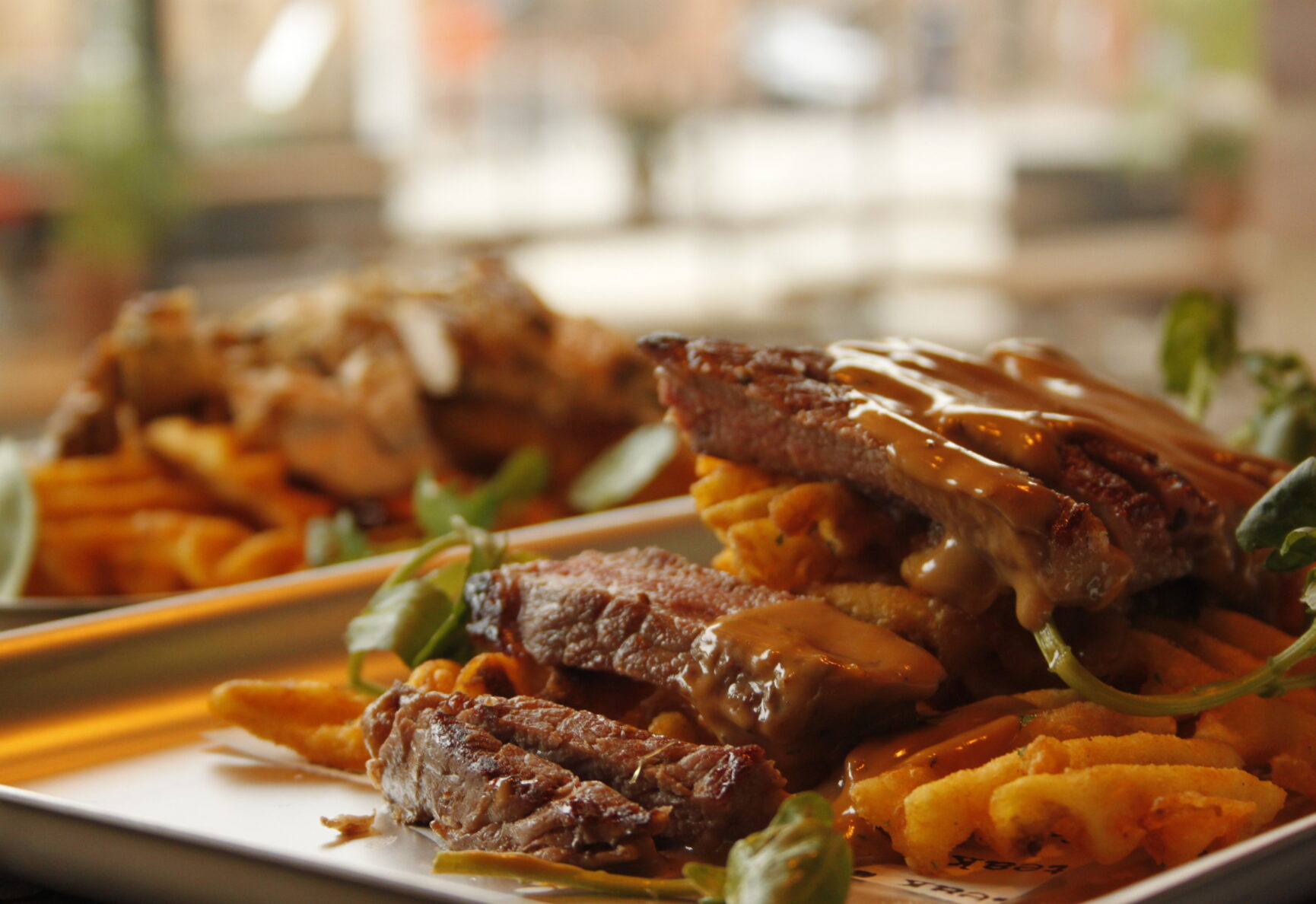 A serving of steak and smoked pepper corn sauce with a side of beef dripping house seasoned fries.