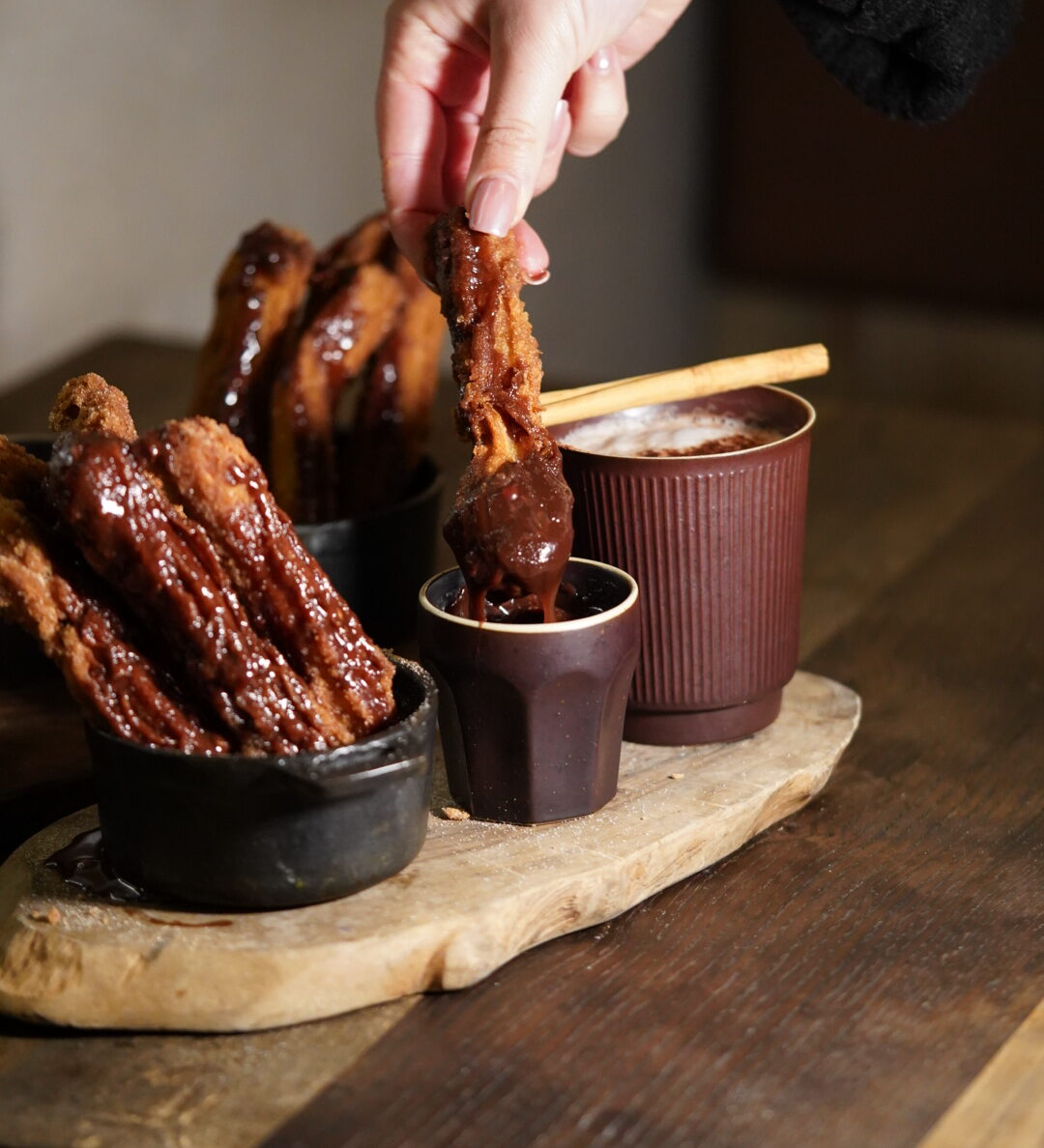 Elote's Churros. One is being dipped into Hazelnut Chocolate sauce.