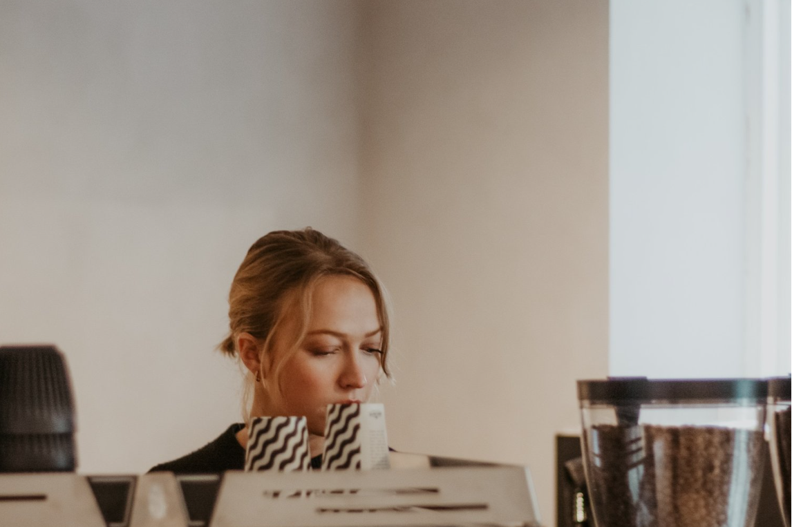 Sophie, owner of Scandinavian Coffee Pod, stands behind the coffee bar prepping an order.