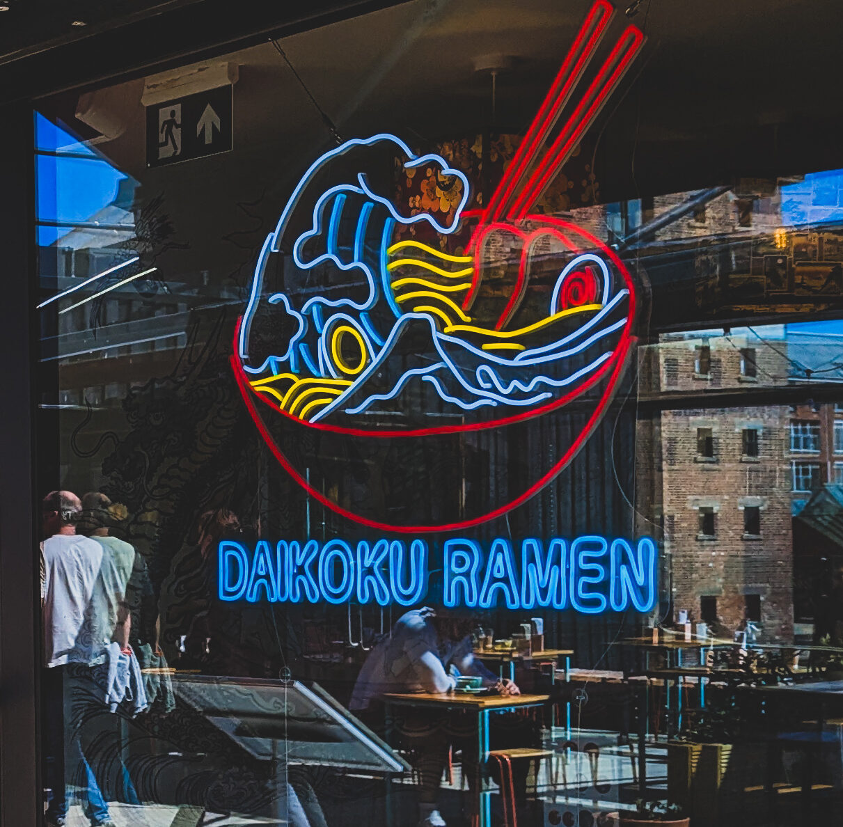 Daikoku's neon sign in the window. The window also reflects Gloucester Docks buildings.