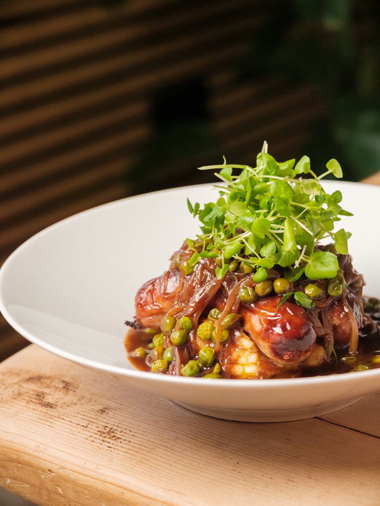 The Roots and Seeds Sausage and Mash, with peas and cress as a garnish, smothered in gravy.