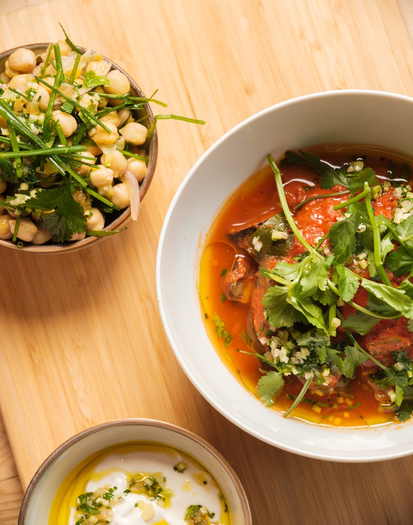 Looking down on three different Roots and Seeds dishes, all garnished with fresh greens.